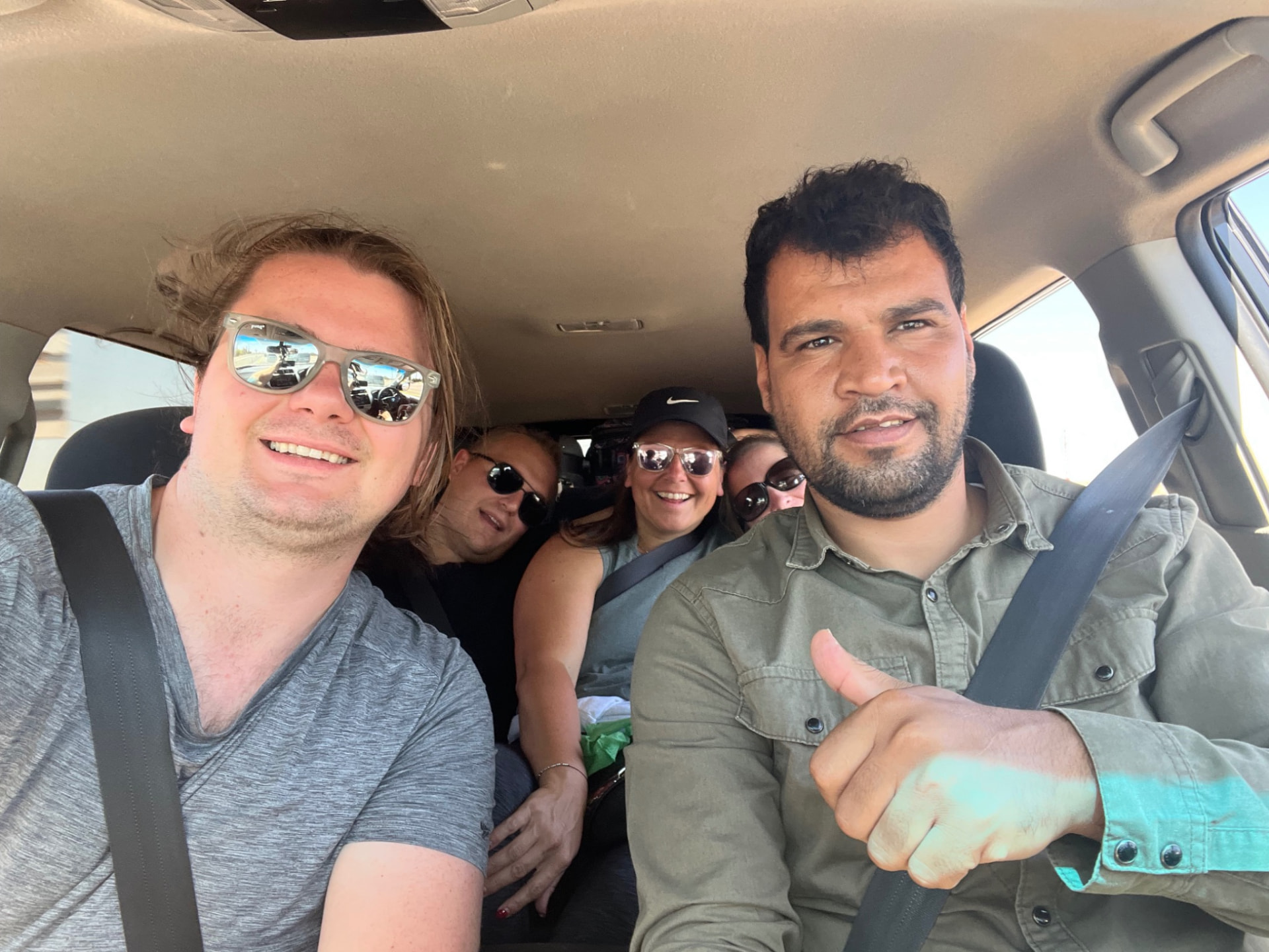 Travellers and their private driver inside the vehicle during a road journey in Morocco