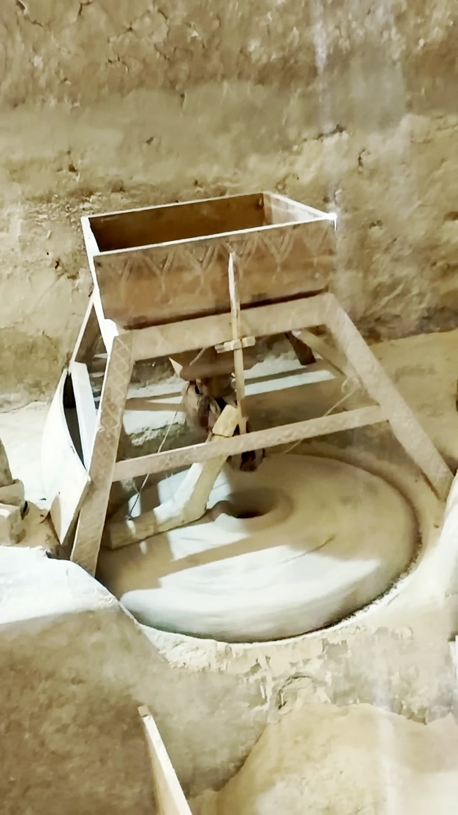 Millstone and wooden grain hopper at the watermill seen during Oualid’s Tiout visit